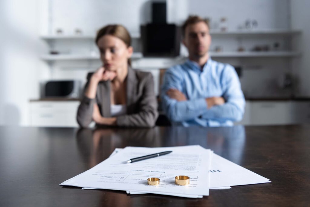 couple sitting with divorce papers image Couple sitting at table with divorce papers